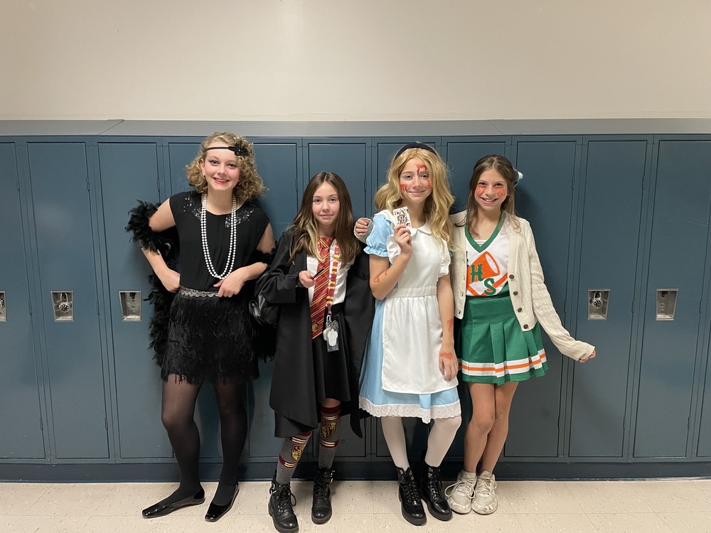 group of middle school students in hallloween costumes in front of lockers